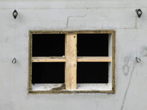 Aussparung in einer betonierten Kellerwand für ein Kellerfenster.